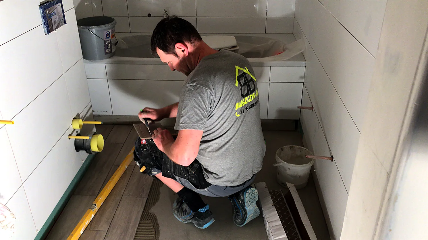 Handwerker von B-Ausbau beim Ausrichten im Bad